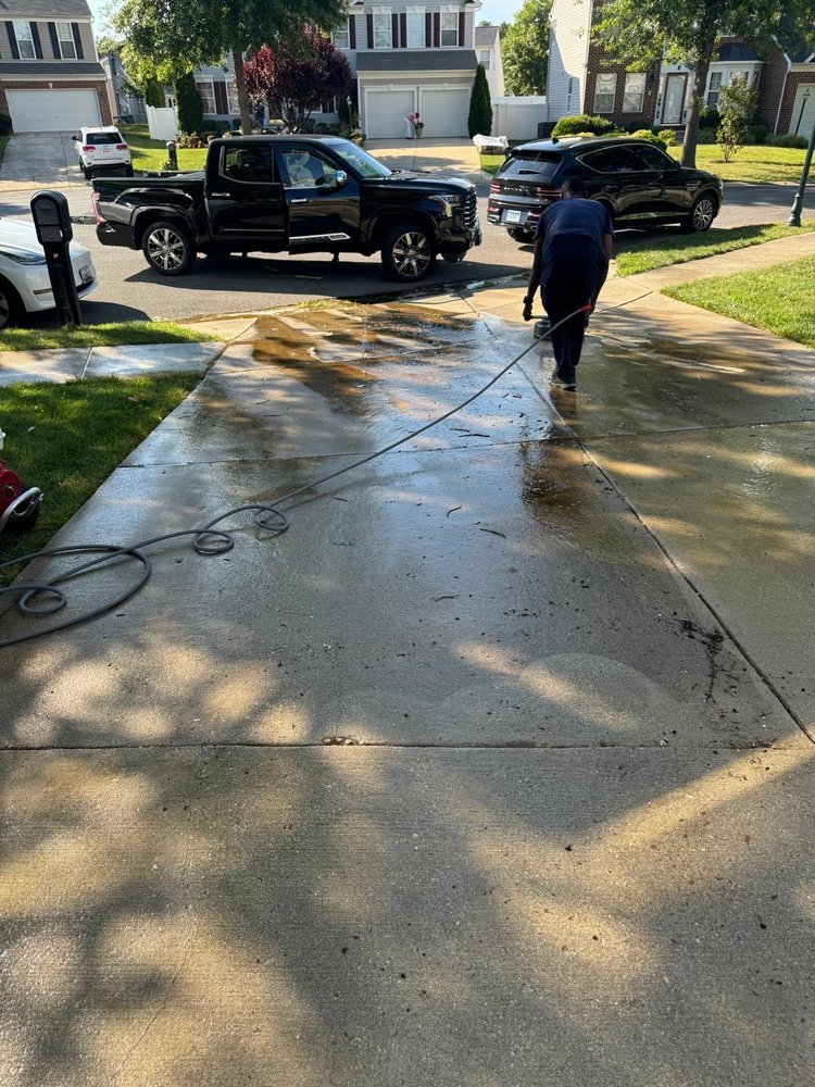 Technician pressure washing the exterior of a brick building